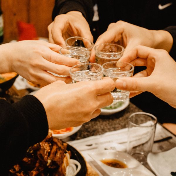 People drinking shot glasses of soju