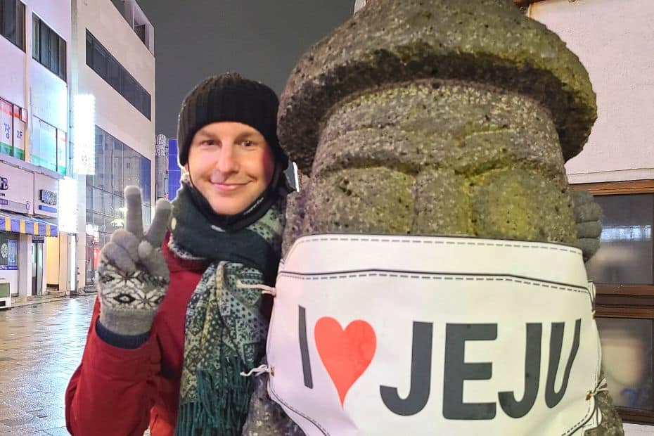 What To Do On Jeju Island In Winter: Jeju Winter Itinerary 2025 7 Standing next to a dol-hareubang in Jeju City
