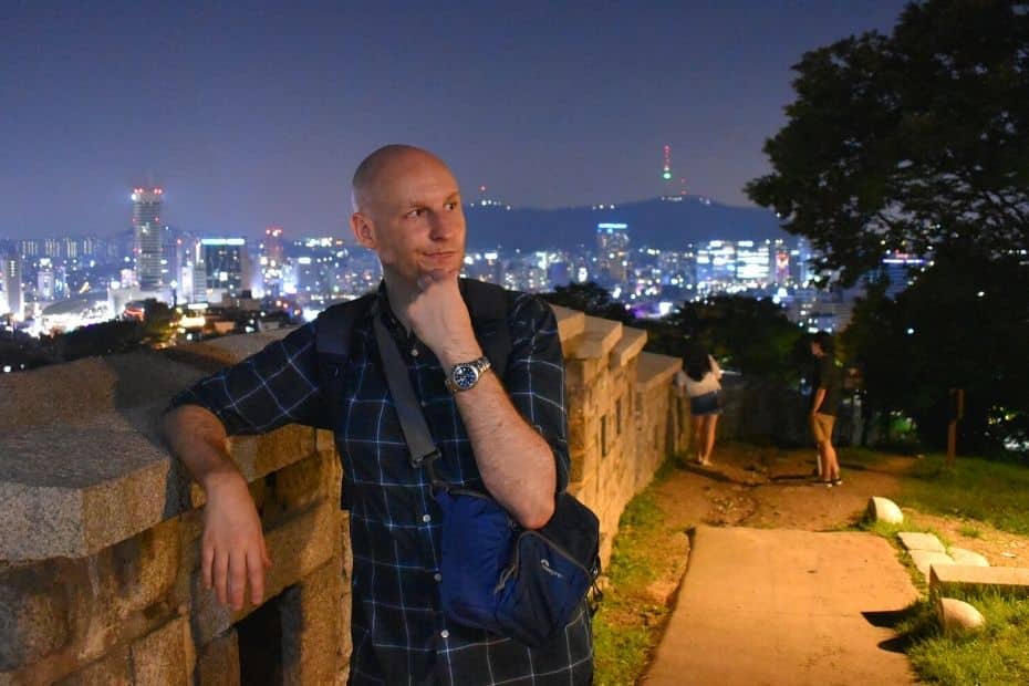 Joel standing by the Seoul Fortress Wall at night in summer in Seoul
