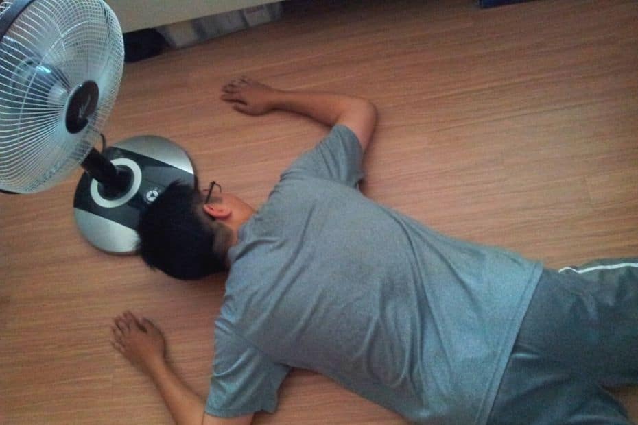 Man passed out next to an electric fan