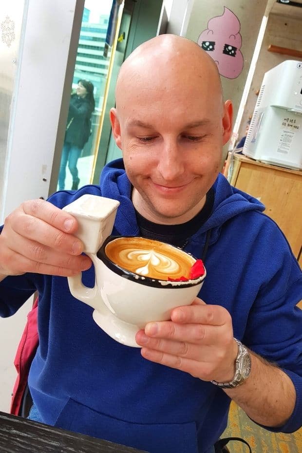 Man drinking cafe latte from a toilet shaped cup in Seoul, Korea