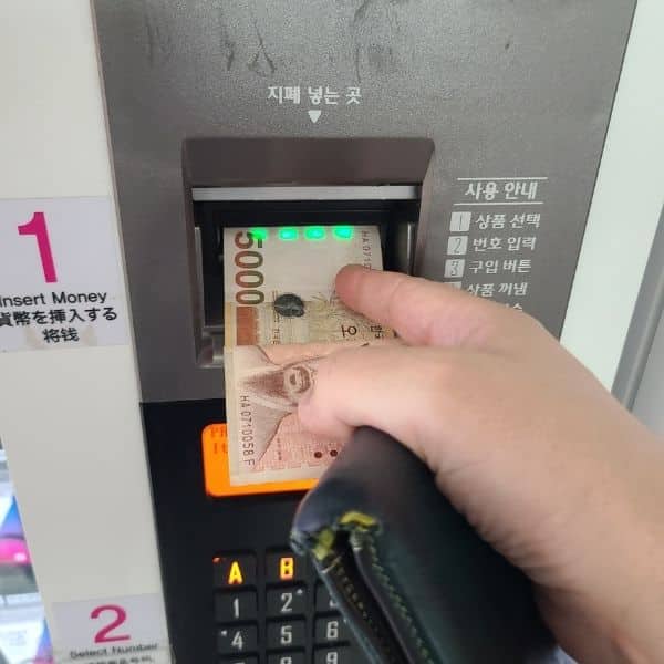 Inserting money to buy a T-Money Card