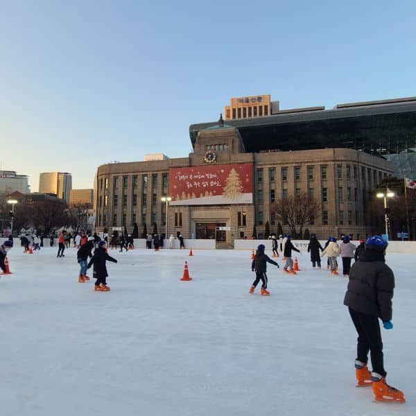 People ice skating outside Seoul City Hall