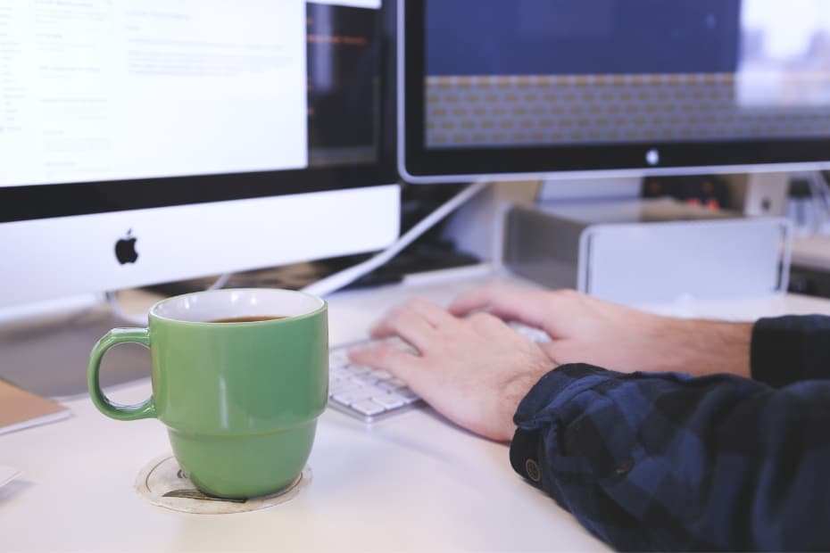 Person using a computer with two screens