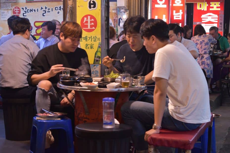 People eating a Korean BBQ meal on the street