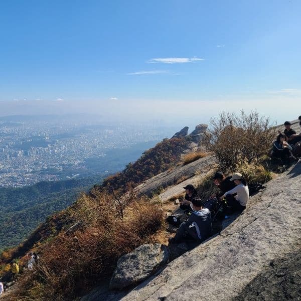 People sitting on Baegundae Peak looking at Seoul