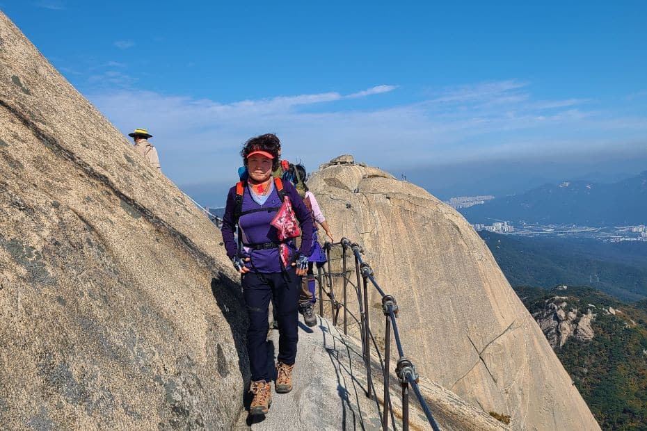 Hiker walking along a rocky path on Baegundae Peak