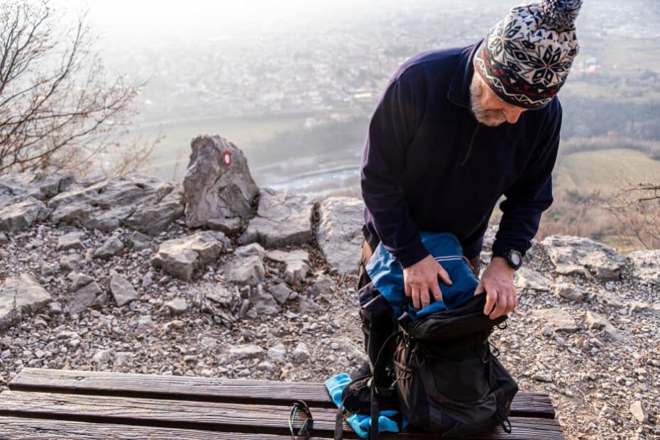 Person packing hiking equipment on a mountain