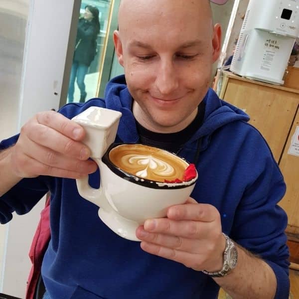 Man holding a toilet shaped coffee cup