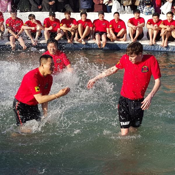 People in ice cold water at Ice Festival in Korea